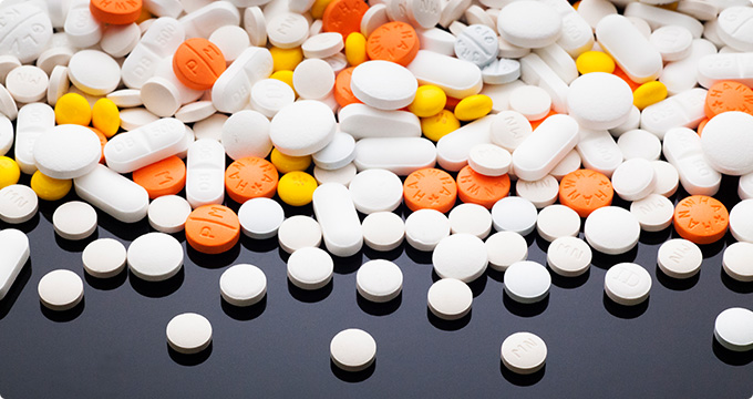 여러종류의 알약들이 책상위에 흩뿌리진 사진